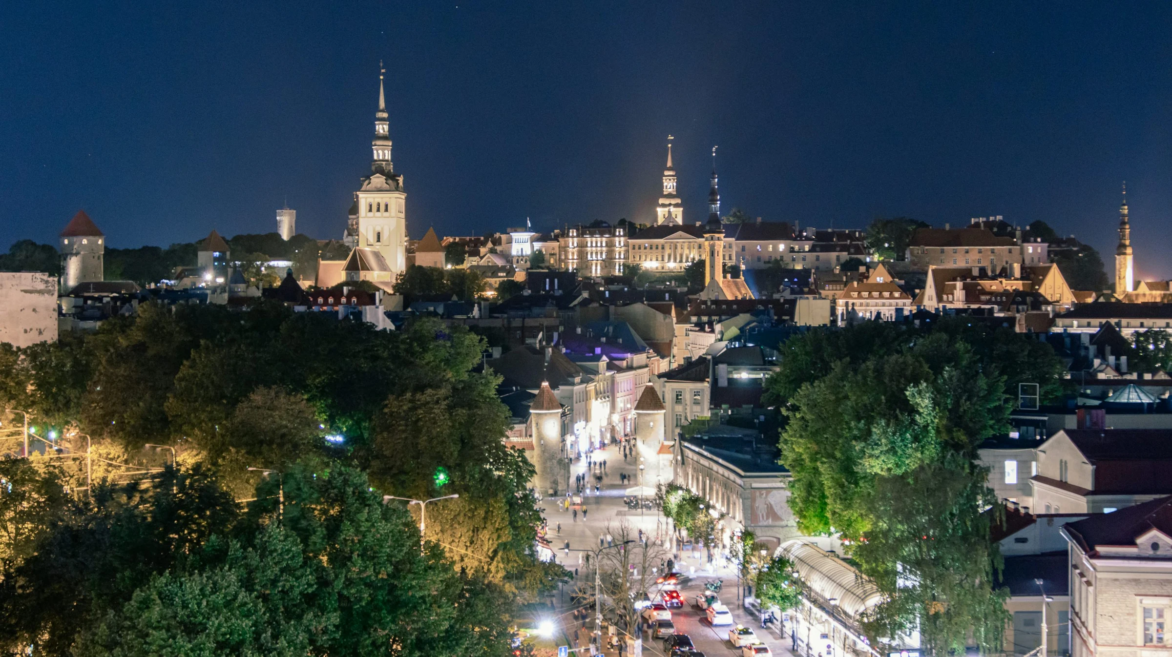 The illuminated rooftops and church spires of Tallinn’s Old Town at dusk